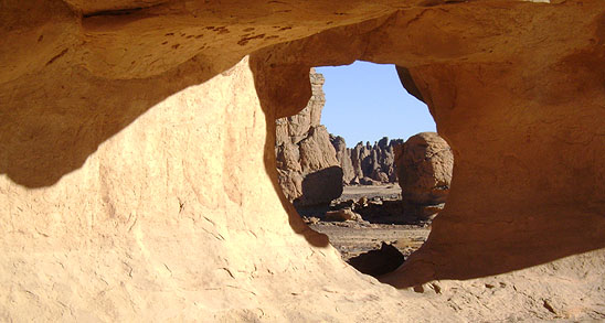 Blick durch einen Tunnel auf imposante Felsskulpturen, Tassili N'Ajjer, Algerien